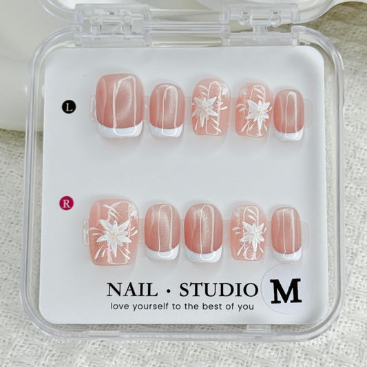 Handmade press-on nails: white French tips with flower designs for a polished look.