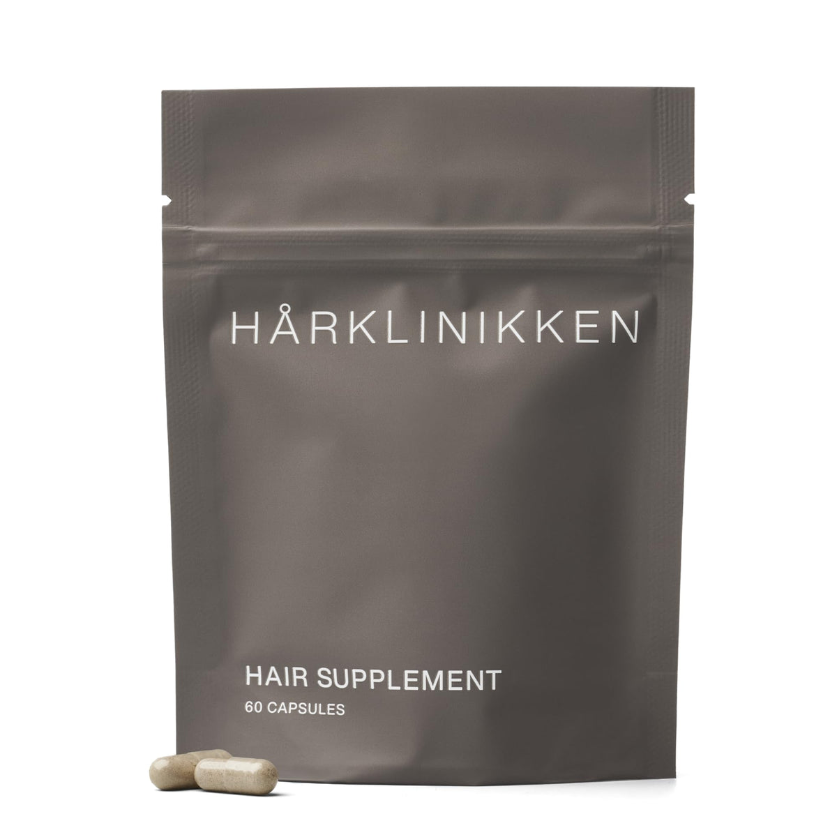 Harklinikken Hair Supplement bottle close-up showing vegan capsules for fuller-looking hair.