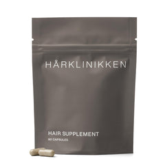 Harklinikken Hair Supplement bottle close-up showing vegan capsules for fuller-looking hair.