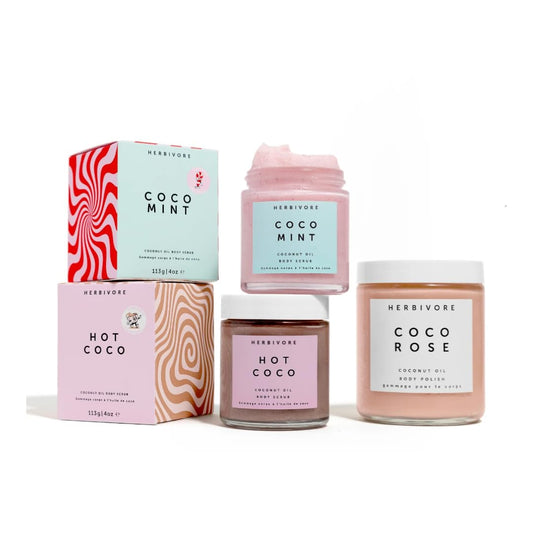 HERBIVORE Coco Mint Body Scrub bottle in hand demonstrates easy body exfoliation and hydration.