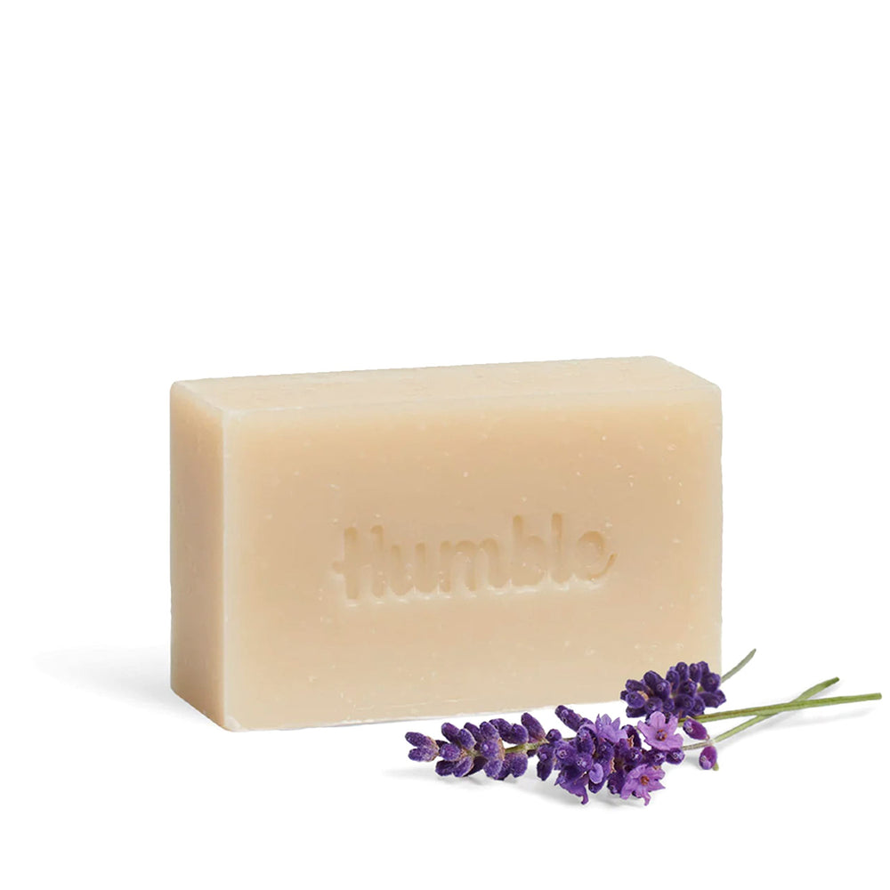 Humble Brands Mountain Lavender bar on wooden surface beside lavender blossoms