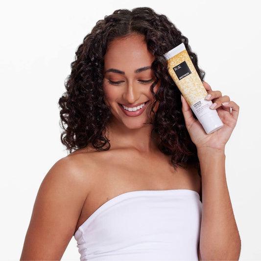 IGK Mistress balm texture shown during application delivers frizz control and smoothness.