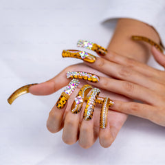 Leopard cat eye nails in gold metallic with shimmering accents for statement style.