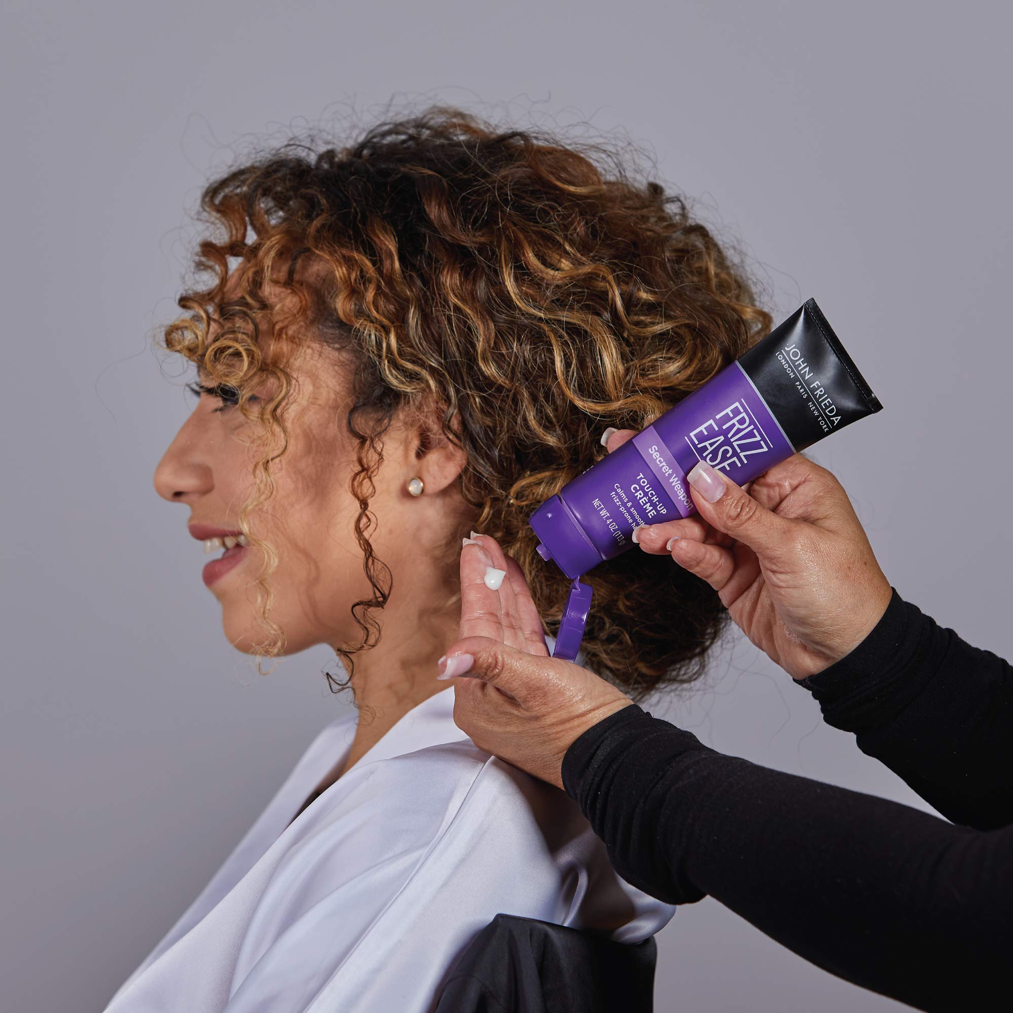 Creamy texture spread on fingers before applying to hair.