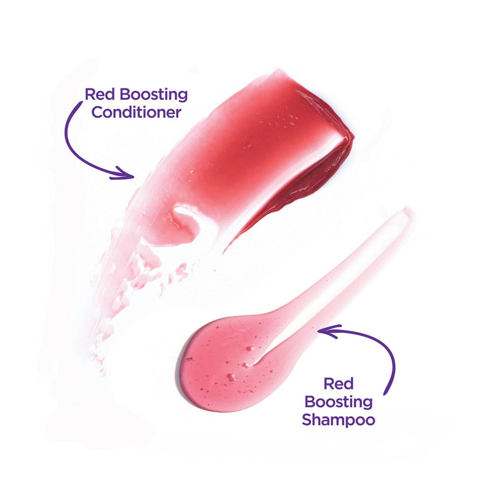 Applying Radiant Red conditioner to wet hair for color-boosted nourishment.