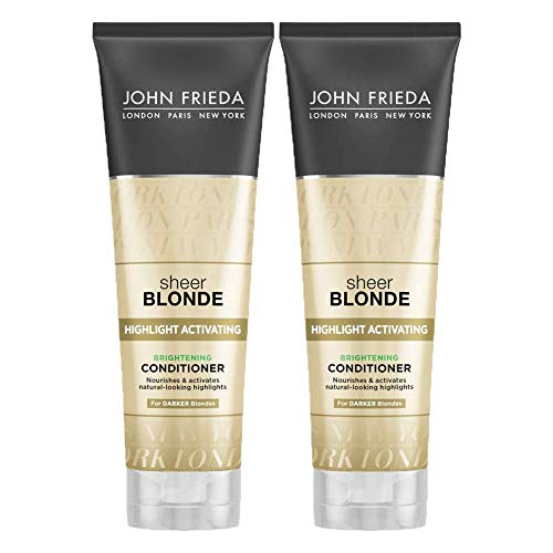 Close-up applying conditioner to dark blonde hair for reactivated highlights