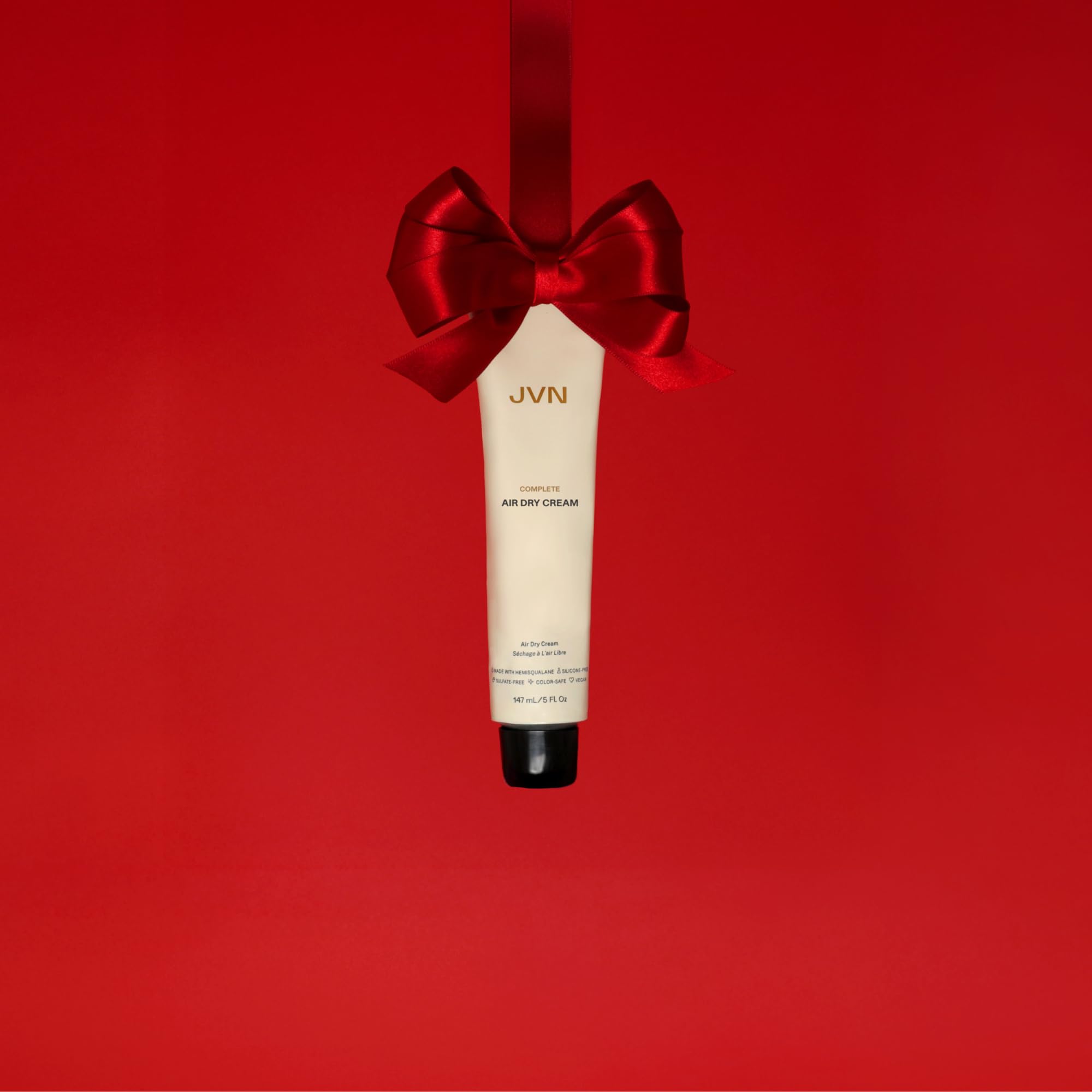 Hands applying JVN No Heat Complete Air Dry Cream for no-heat styling