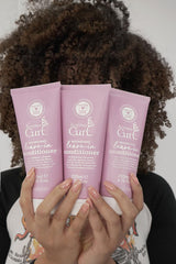 Kozma Curl Nourishing Leave-In bottle shows lightweight hydration for soft, touchable curls.
