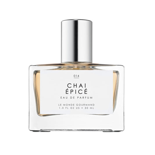 Le Monde Gourmand Chai Épicé spray bottle on wooden surface highlights warm, woody notes.