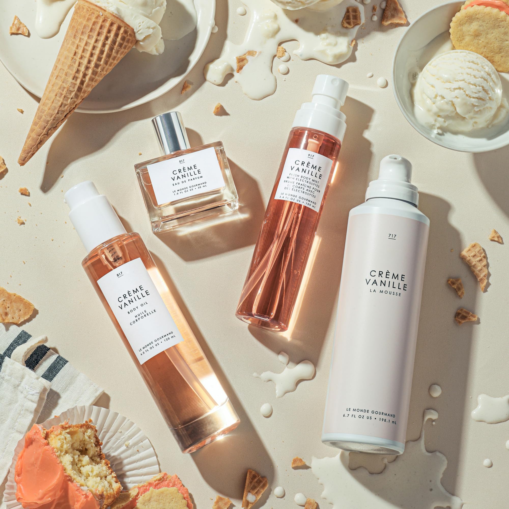 Le Monde Gourmand Crème Vanille bottle on vanity with jasmine backdrop for day-to-night versatility.