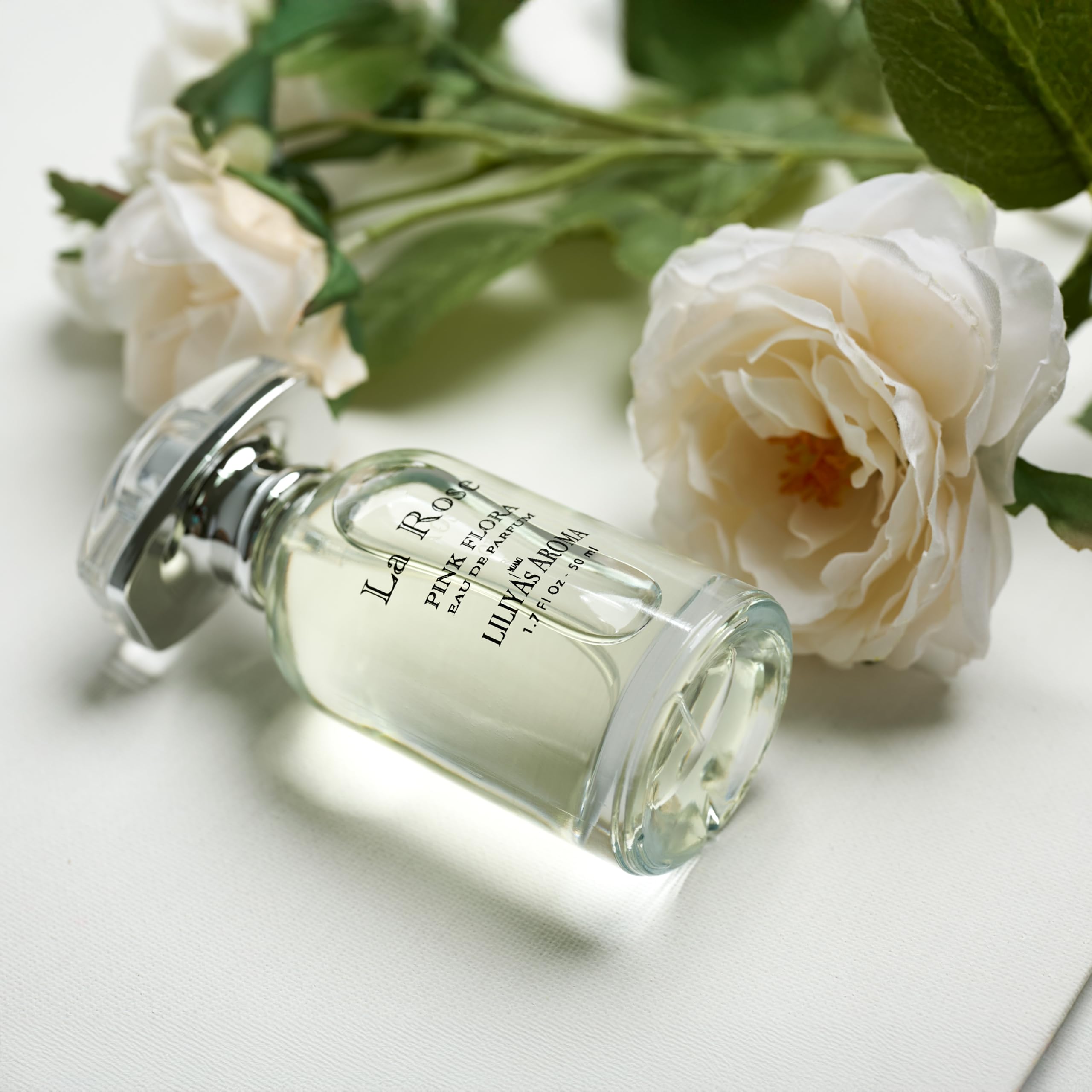 Liliya's Aroma La Rose bottle with blossoms shows romantic floral allure for daily wear