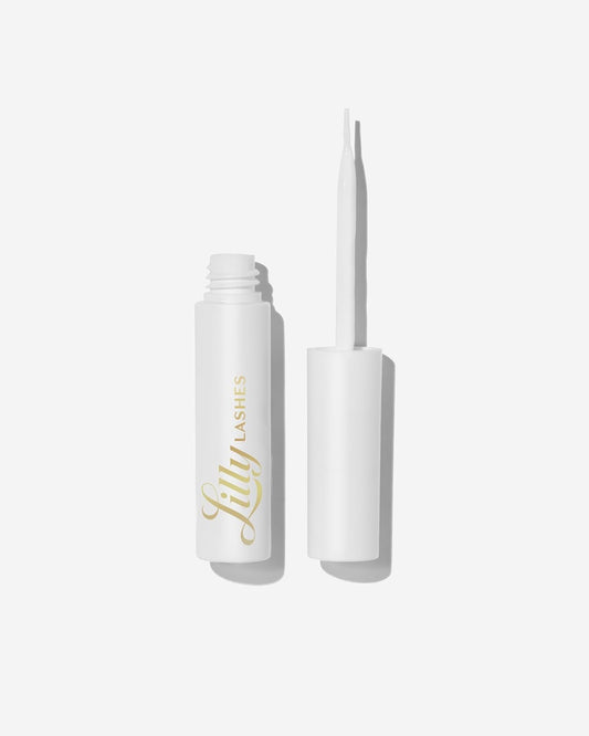 Lilly Lashes clear glue bottle with brush-on applicator for precise lash placement.