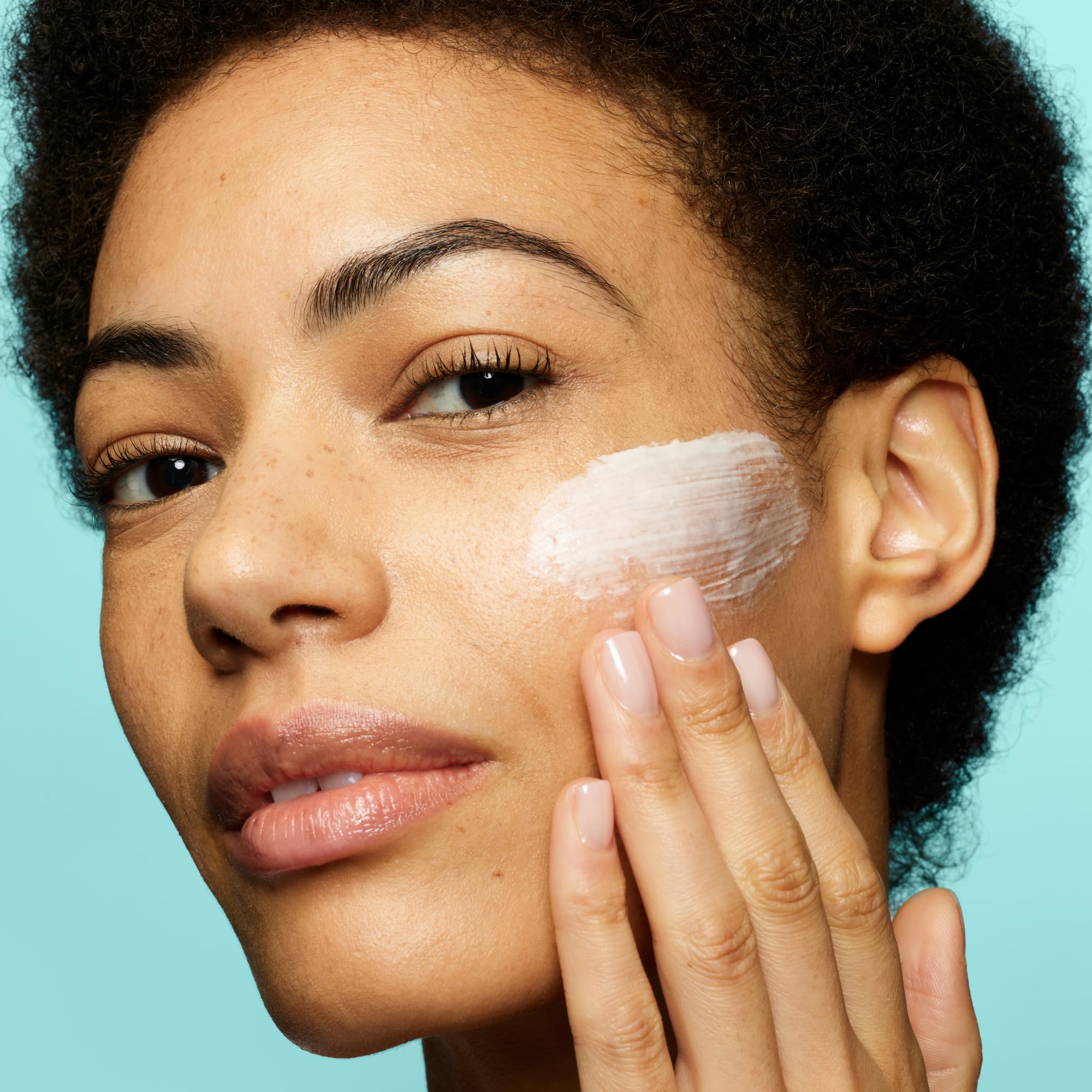 Hands massaging Liz Earle Cleanse & Polish onto dry skin for cleansing