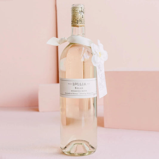 Lollia Relax Bubble Bath featuring white flower corsage on premium display