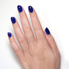 Close-up of Cocktail Hour bottle with glossy royal blue shade on swatch