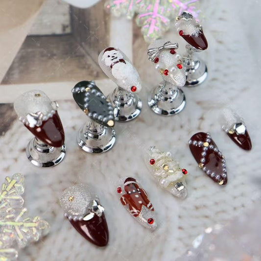 Maigitur nails featuring a Christmas tree rhinestone motif on dark red almond tips.