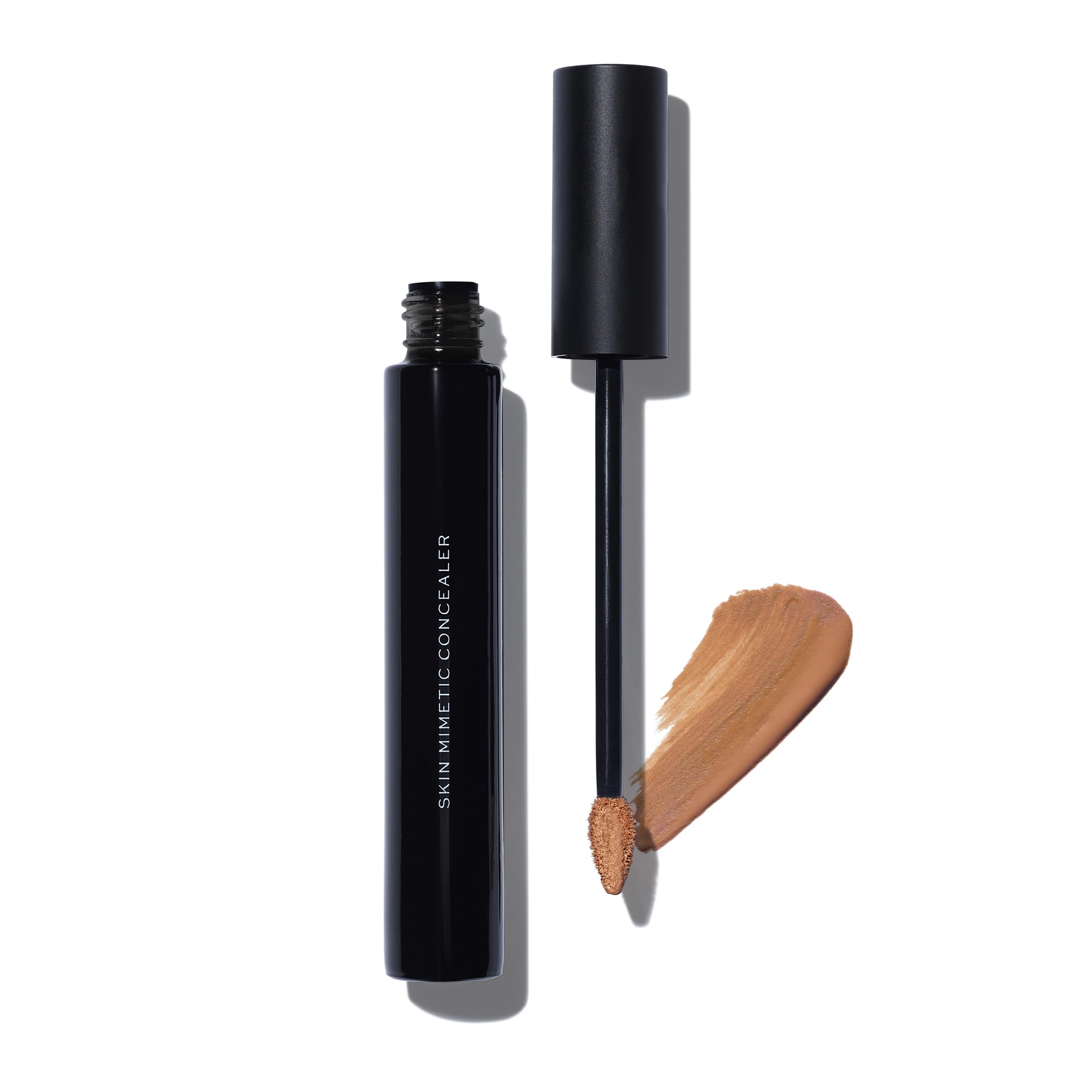 MAKE Beauty Skin Mimetic Concealer tube demonstrates precise application for natural coverage.