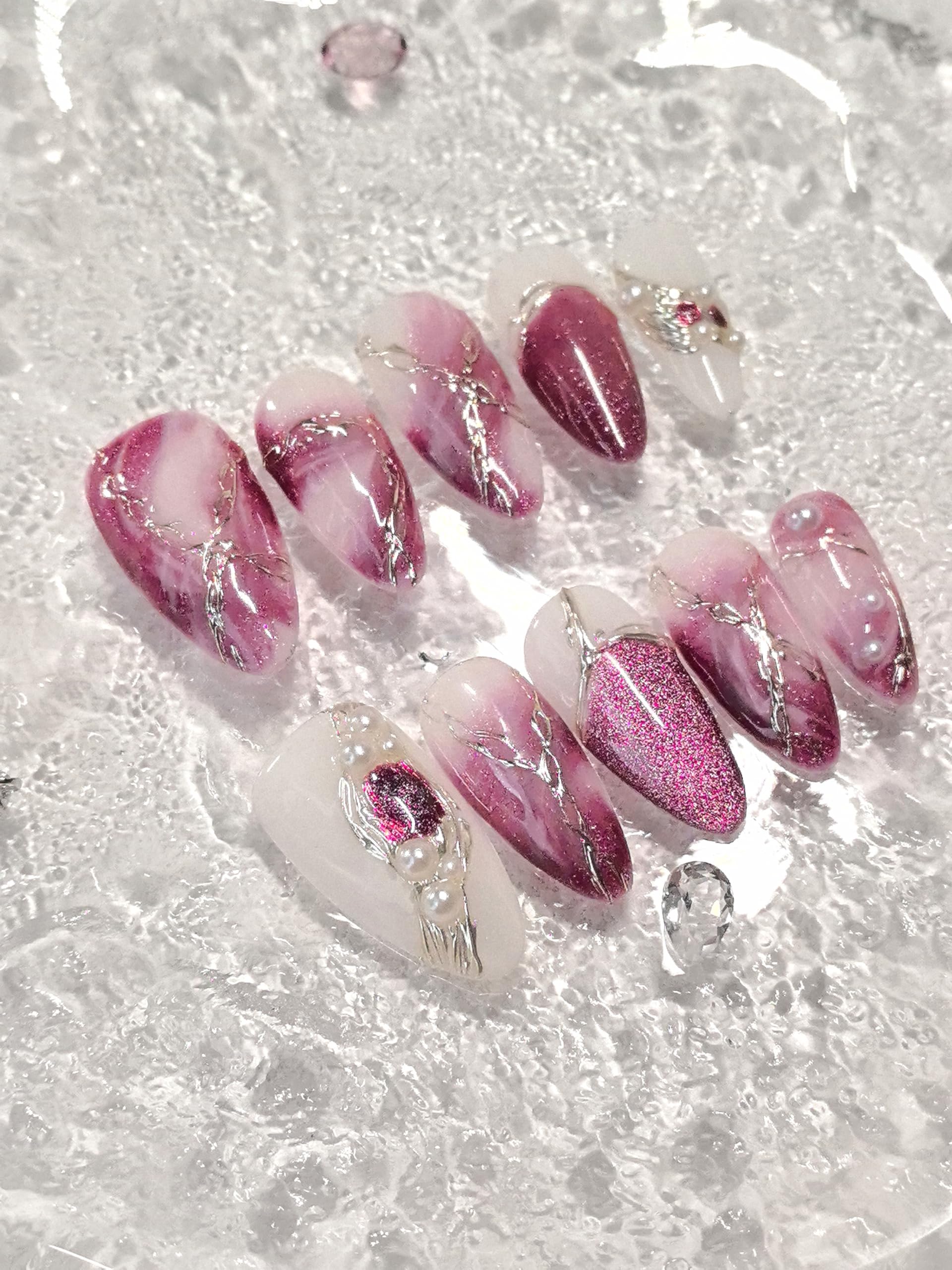 Medium almond nails featuring gold line art and sparkling accents for special occasions