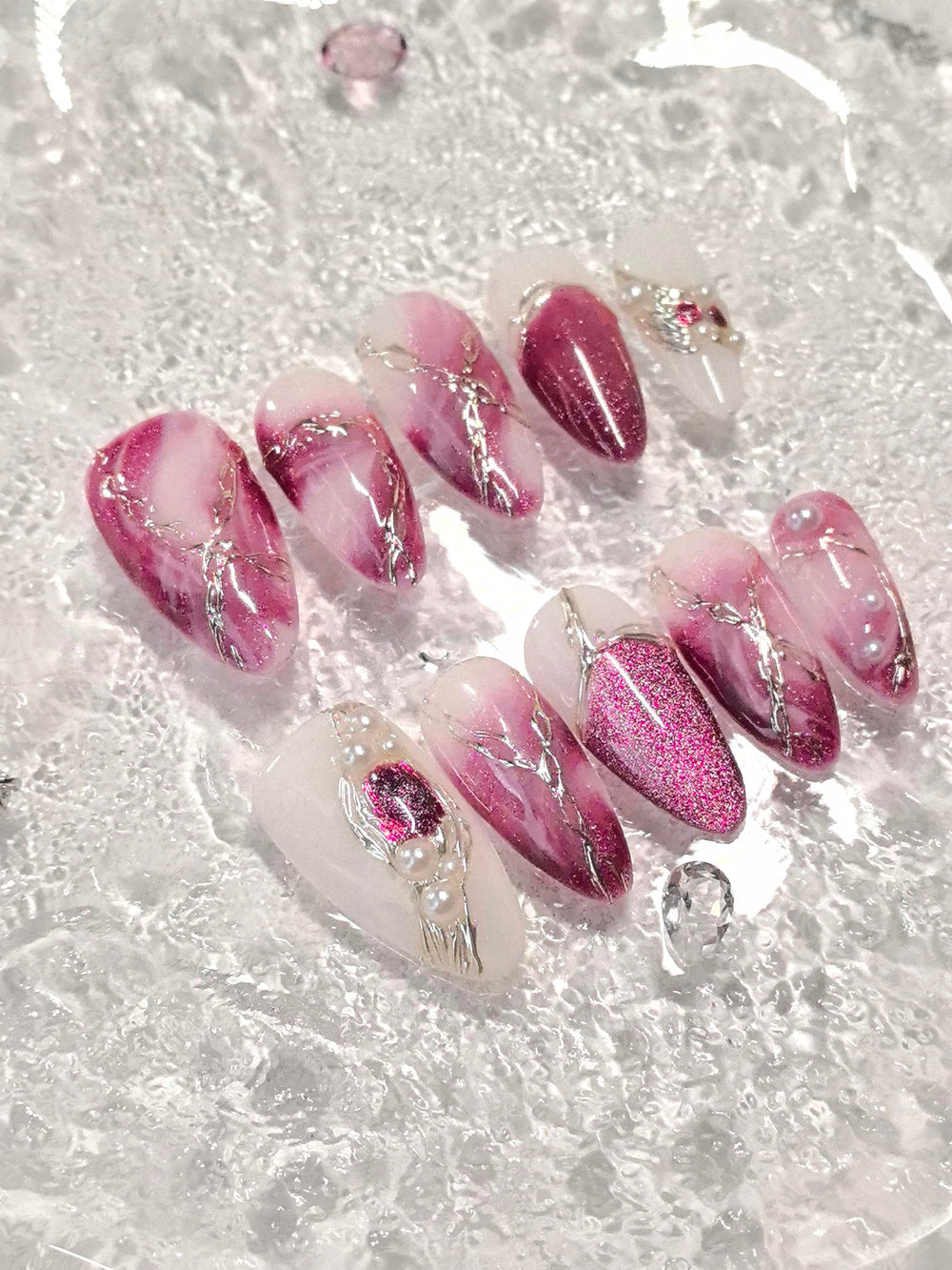 Medium almond nails featuring gold line art and sparkling accents for special occasions