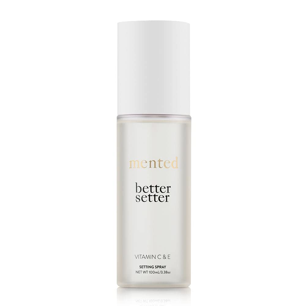 Mented Better Setter spray bottle releasing a fine makeup-setting mist.