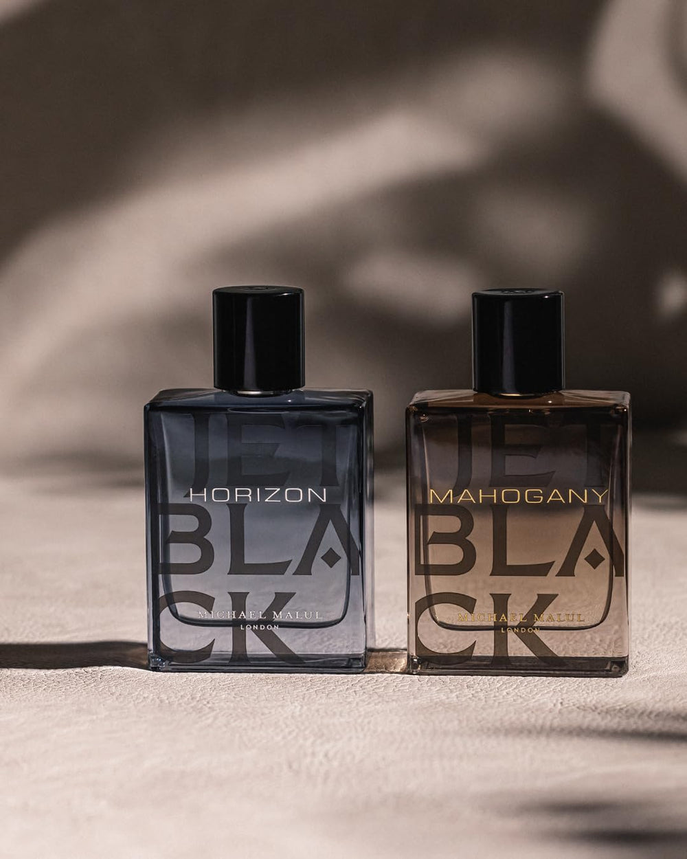 Michael Malul Jet Black Horizon amber liquid seen in splash bottle.