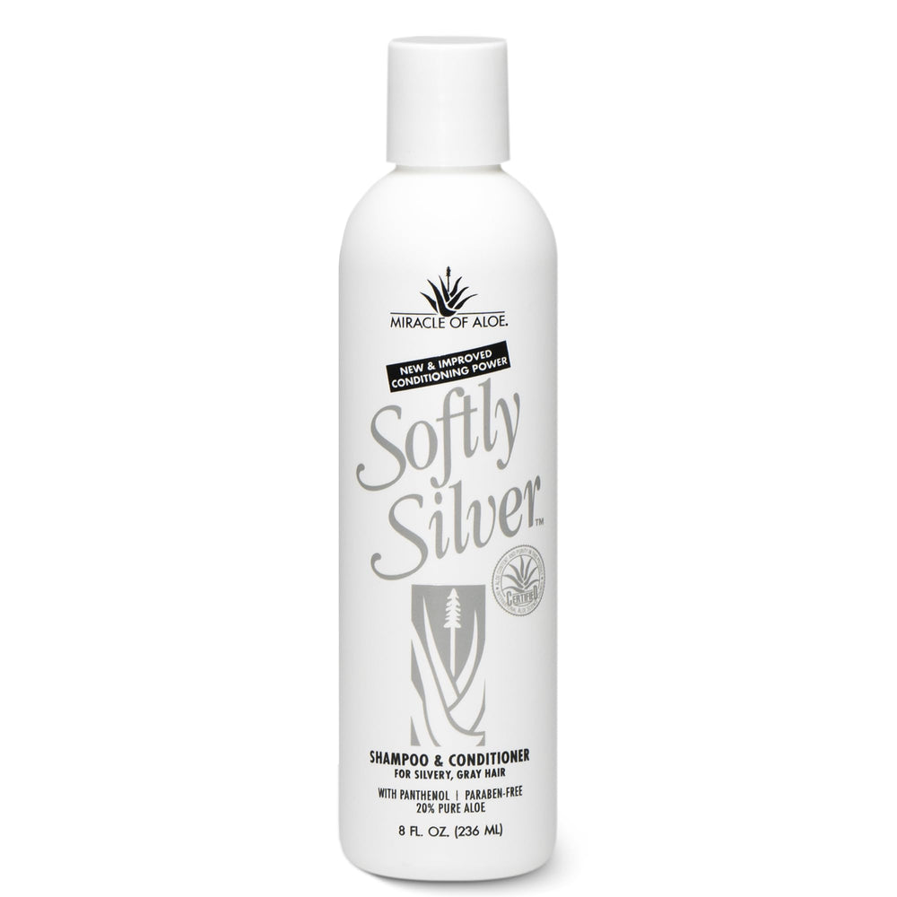 Miracle of Aloe Softly Silver Shampoo on a vanity with shiny, healthy-looking hair.
