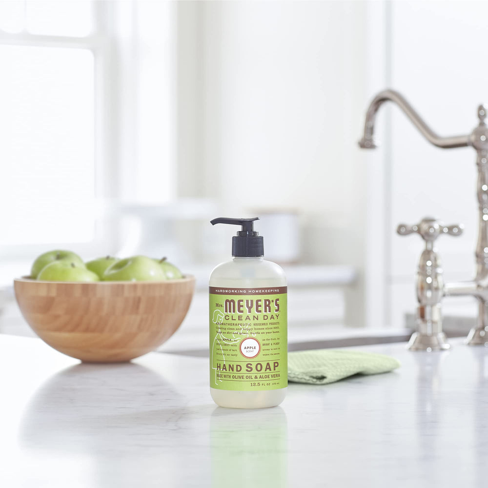 Mrs. Meyer's Apple hand soap hands washing scene illustrating soft cleansing.