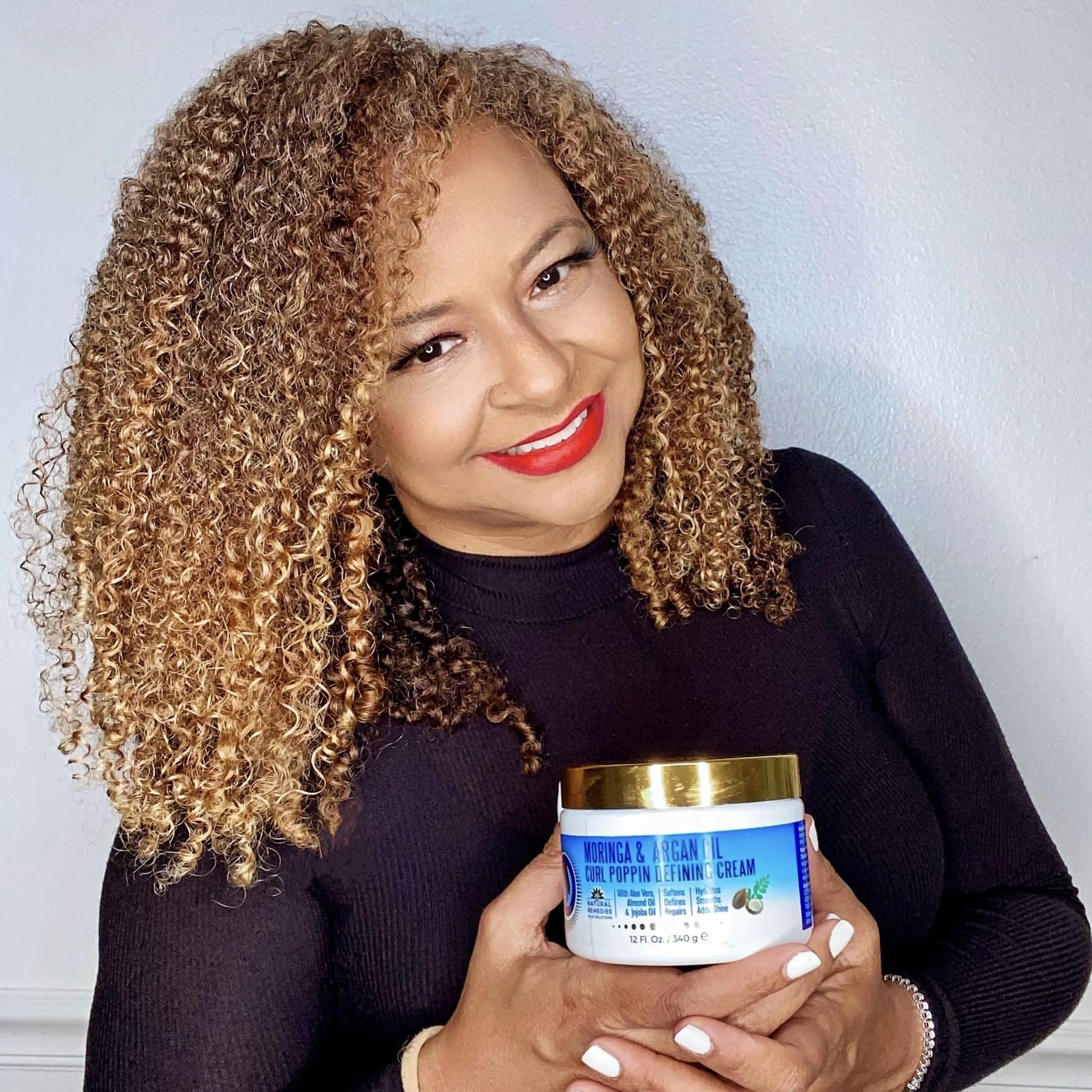 Model showing defined curls with Nefertiti's Secrets Moringa Oil Curl Defining Cream.