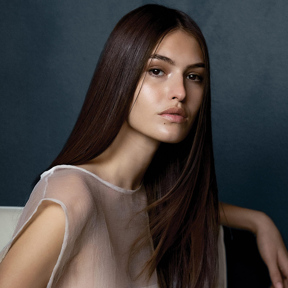 Hair appears smoothed with frizz control after spray.