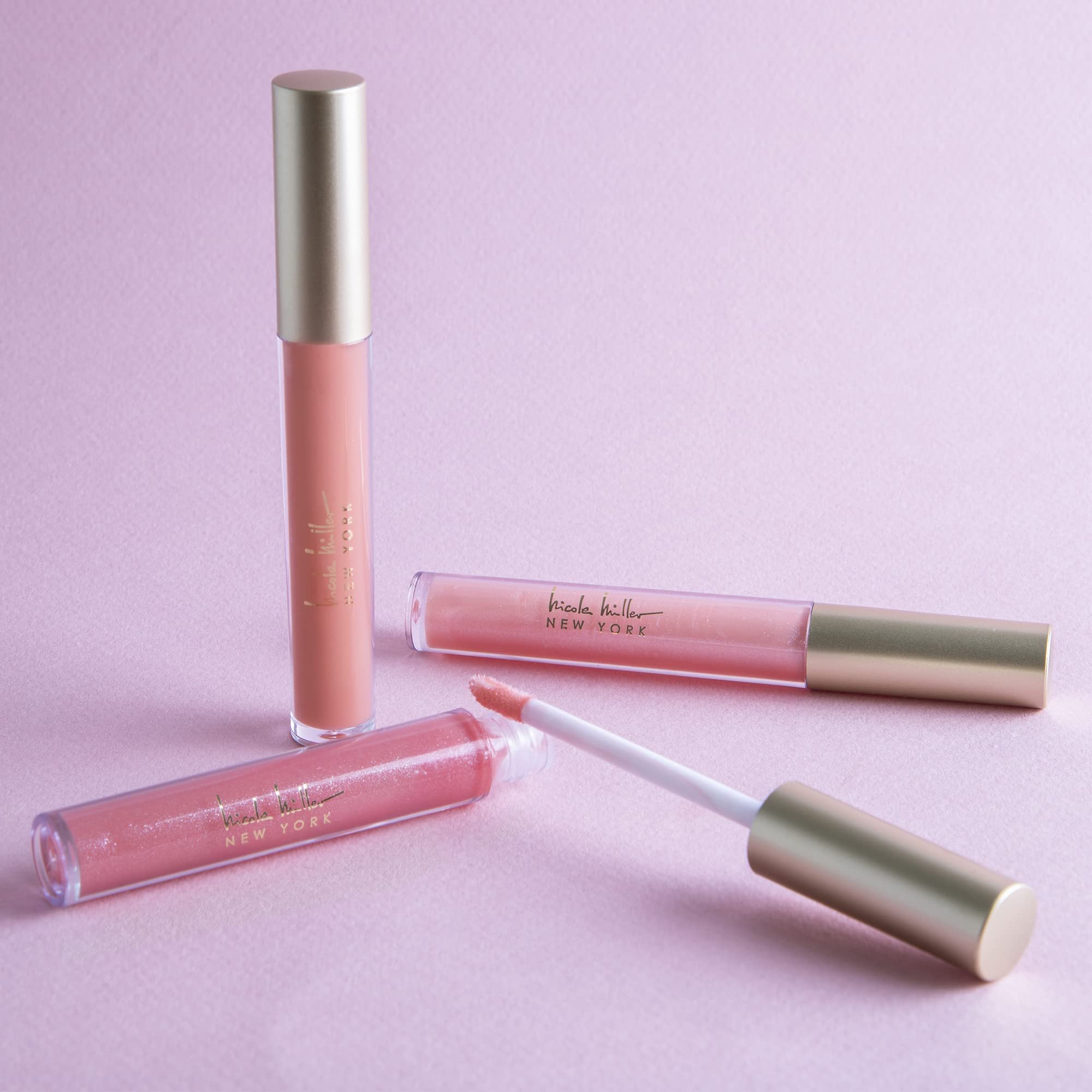 Nicole Miller lip gloss wand applying a shimmering peach shade for radiant lips