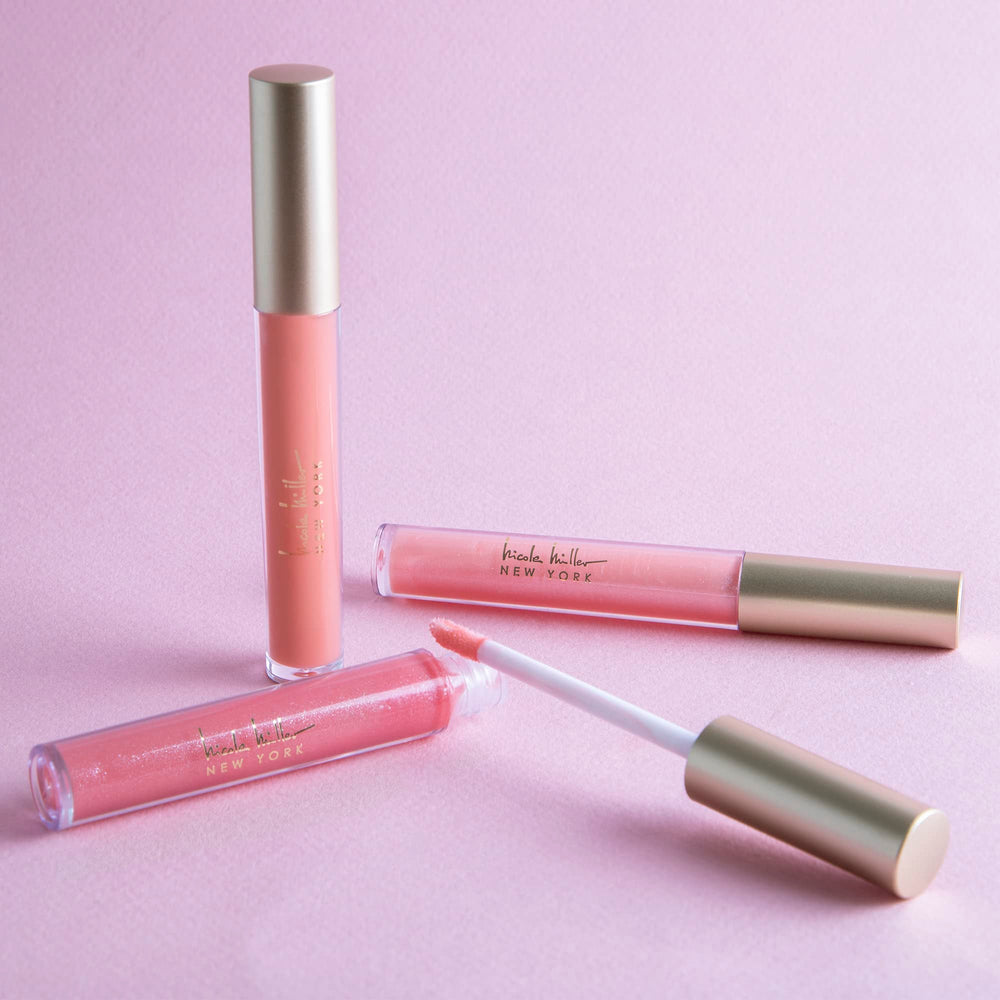 Nicole Miller lip gloss wand applying a shimmering peach shade for radiant lips