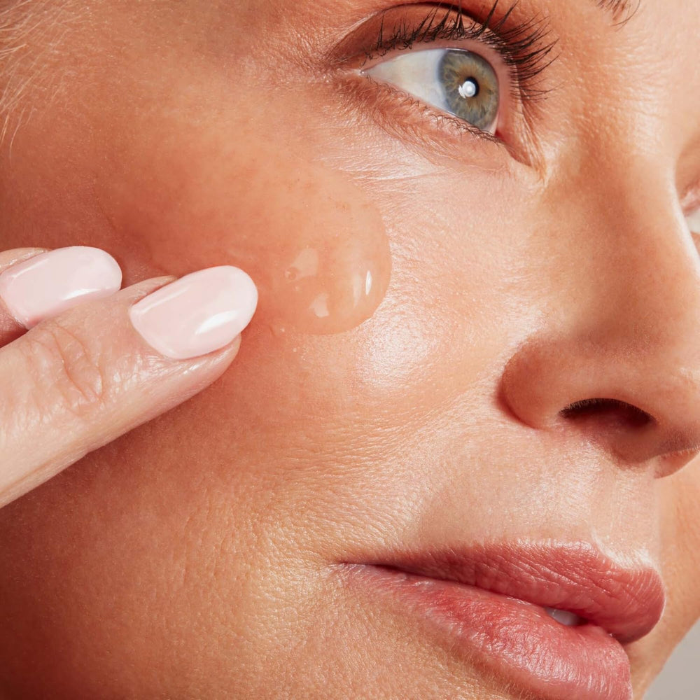 NuFACE applying conductive gel to cheeks for enhanced device performance.