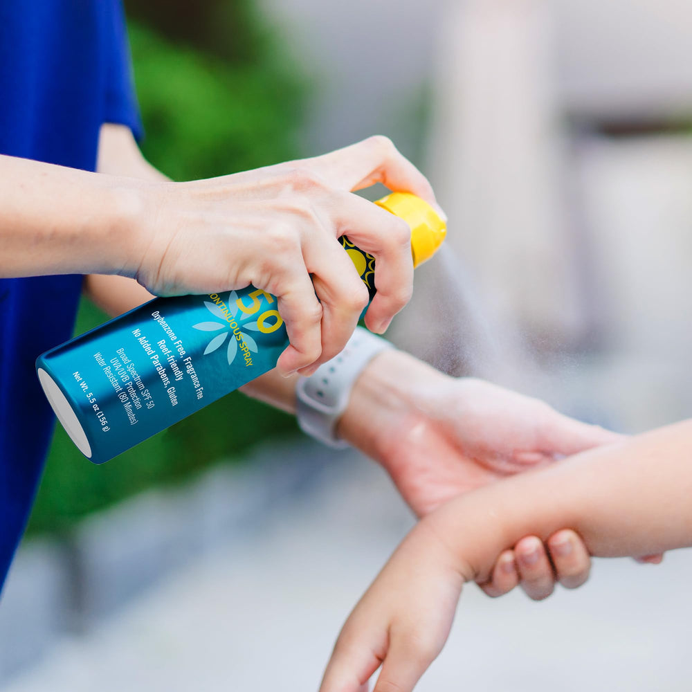 Hands applying Ocean Potion SPF50 on skin during an outdoor activity.