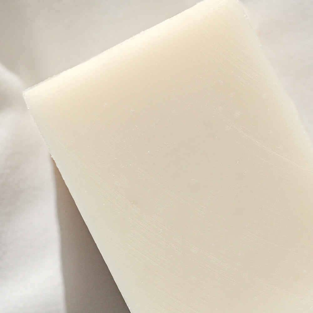 Close-up of Naked Body Soap texture showing creamy lather.