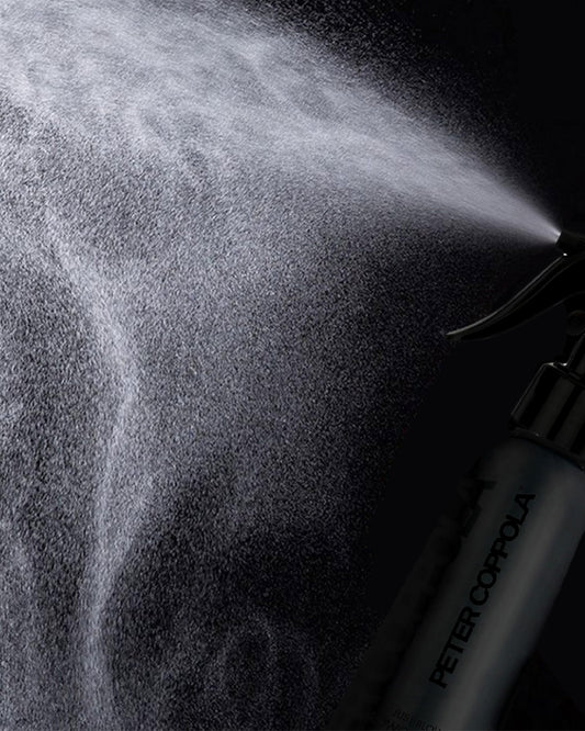 Close-up of mist being sprayed onto damp hair with Just Blow.