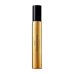 PHLUR Golden Rule bottle close-up with sleek glass for travel-friendly use.