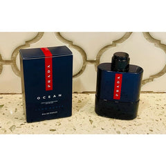 Prada Luna Rossa Ocean mini bottle on a vanity, travel-friendly fragrance for day-to-night use