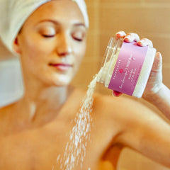 Glass bath salt jar resting on a bath scene