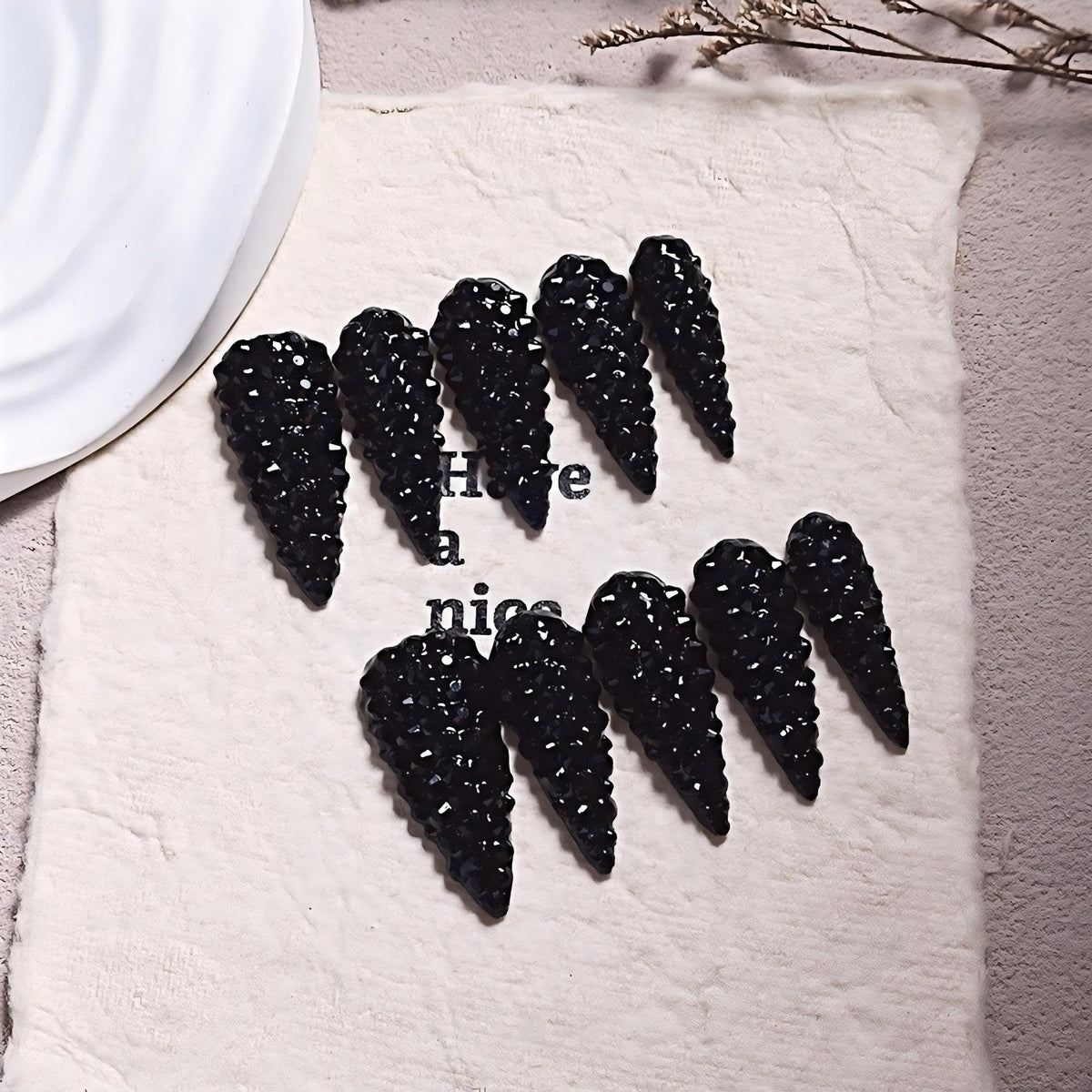 Qicaijia almond press on nails with black rhinestones for a glamorous look.