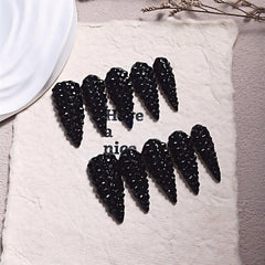 Qicaijia almond press on nails with black rhinestones for a glamorous look.
