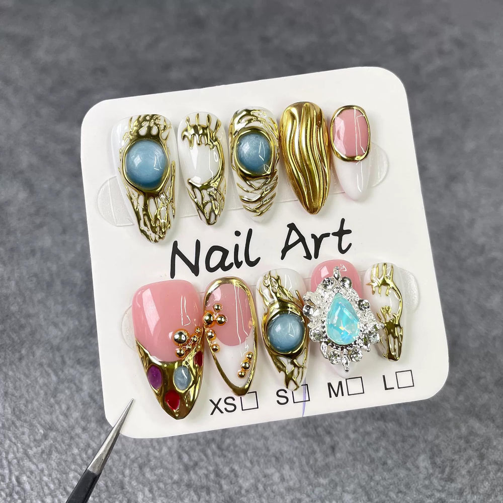 Qicaijia nails feature gold embossed 3D swirl charms for refined party style.