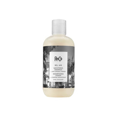 R+Co Bel Air smoothing shampoo bottle close-up for silky, frizz-free hair.