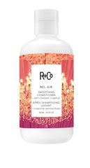 R+Co Bel Air smoothing conditioner bottle angled for frizz control and shine.