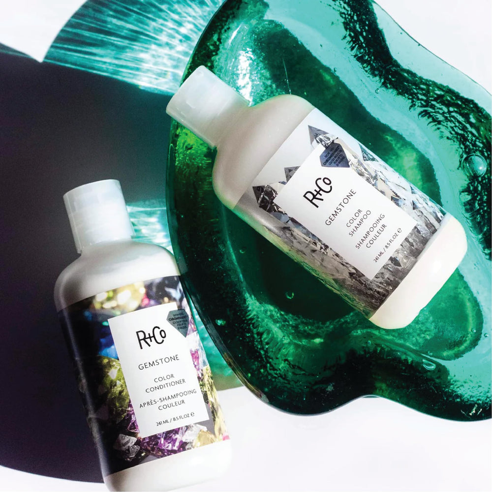 Close-up of R+Co Gemstone Color Conditioner smoothing the hair.