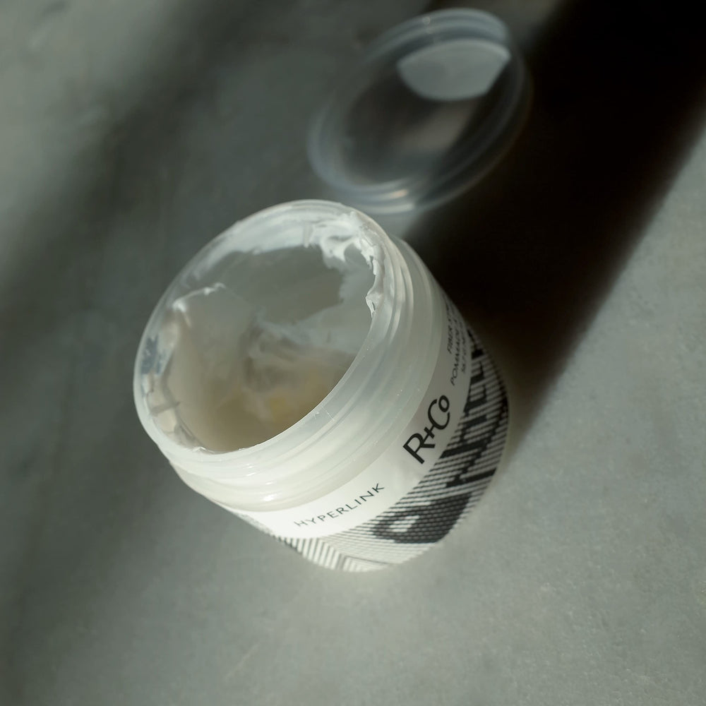R+Co Hyperlink bottle close-up highlighting shine and frizz control