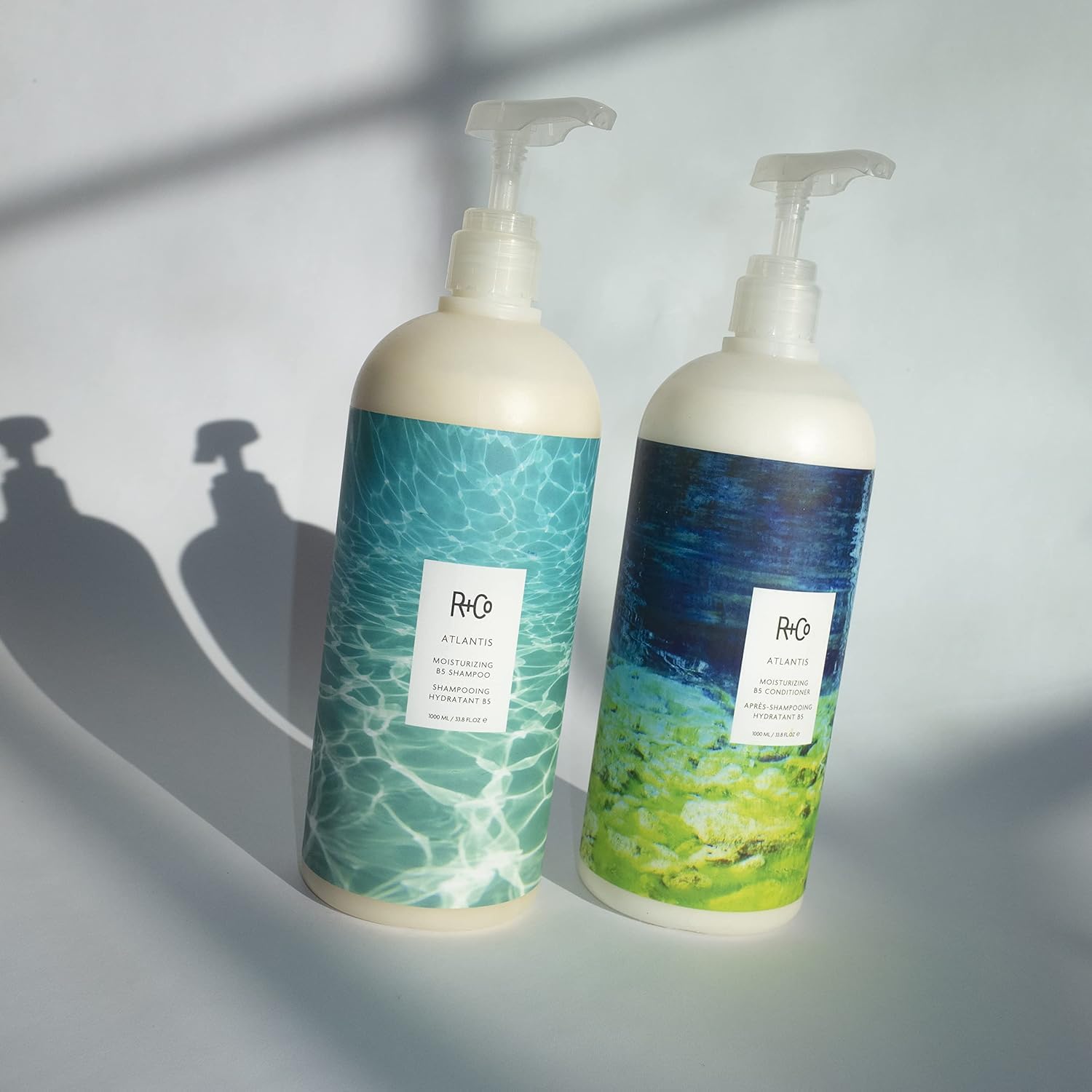 R+Co Atlantis bottle pour demonstrates easy application during shower.