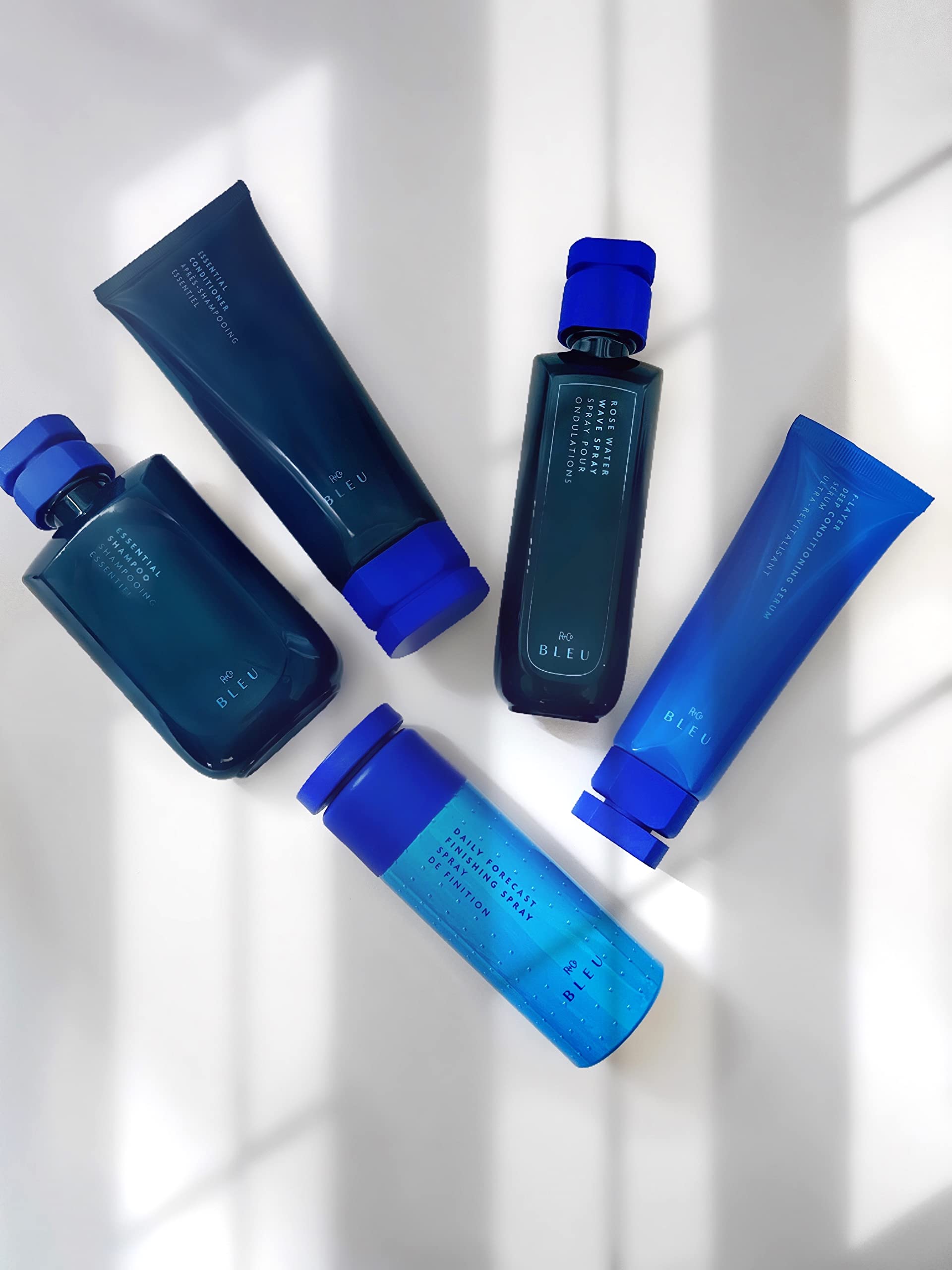 R+Co BLEU F-Layer mist spray mid-dispense for detangling.