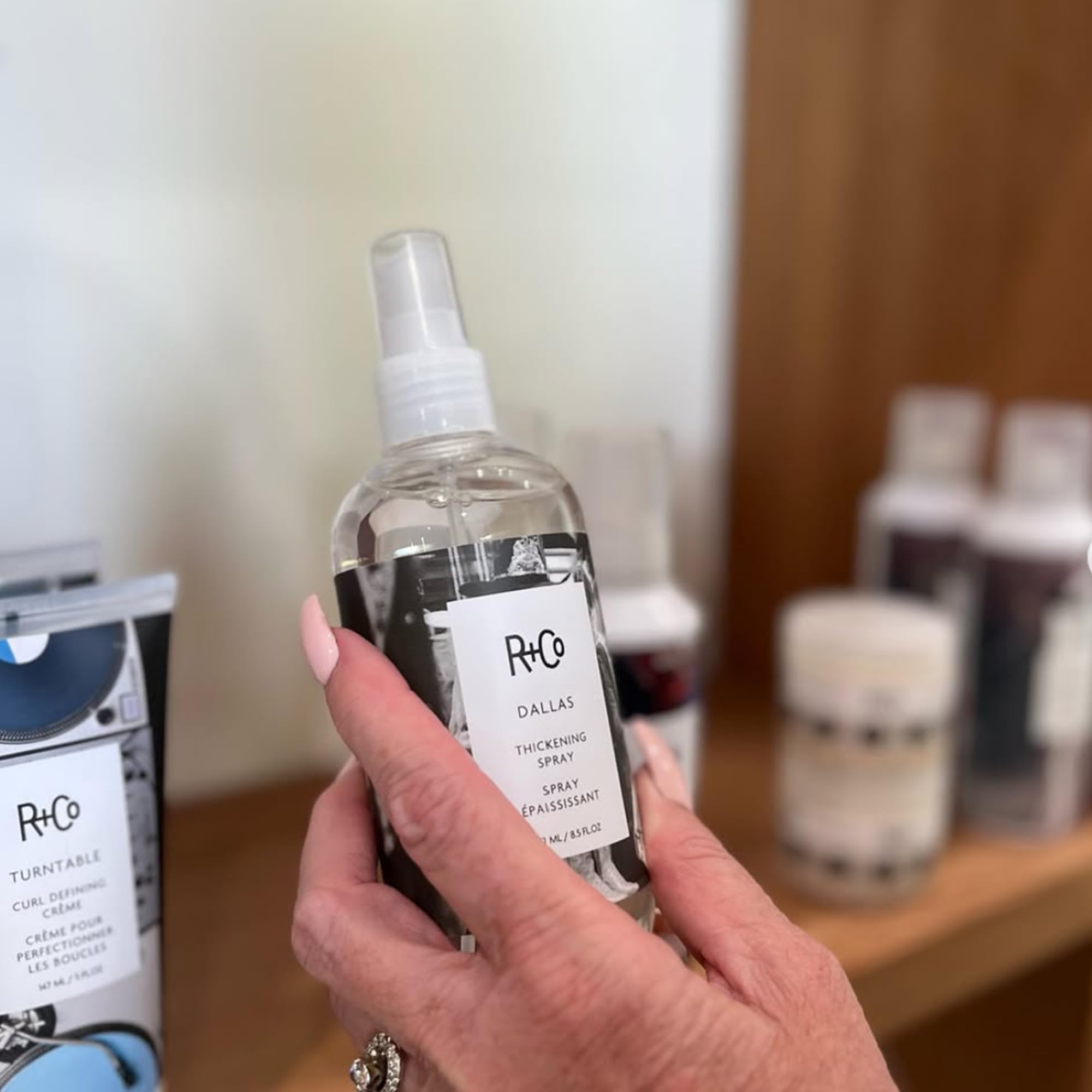 R+Co Dallas spray dispense closeup shows even application for fuller hair.