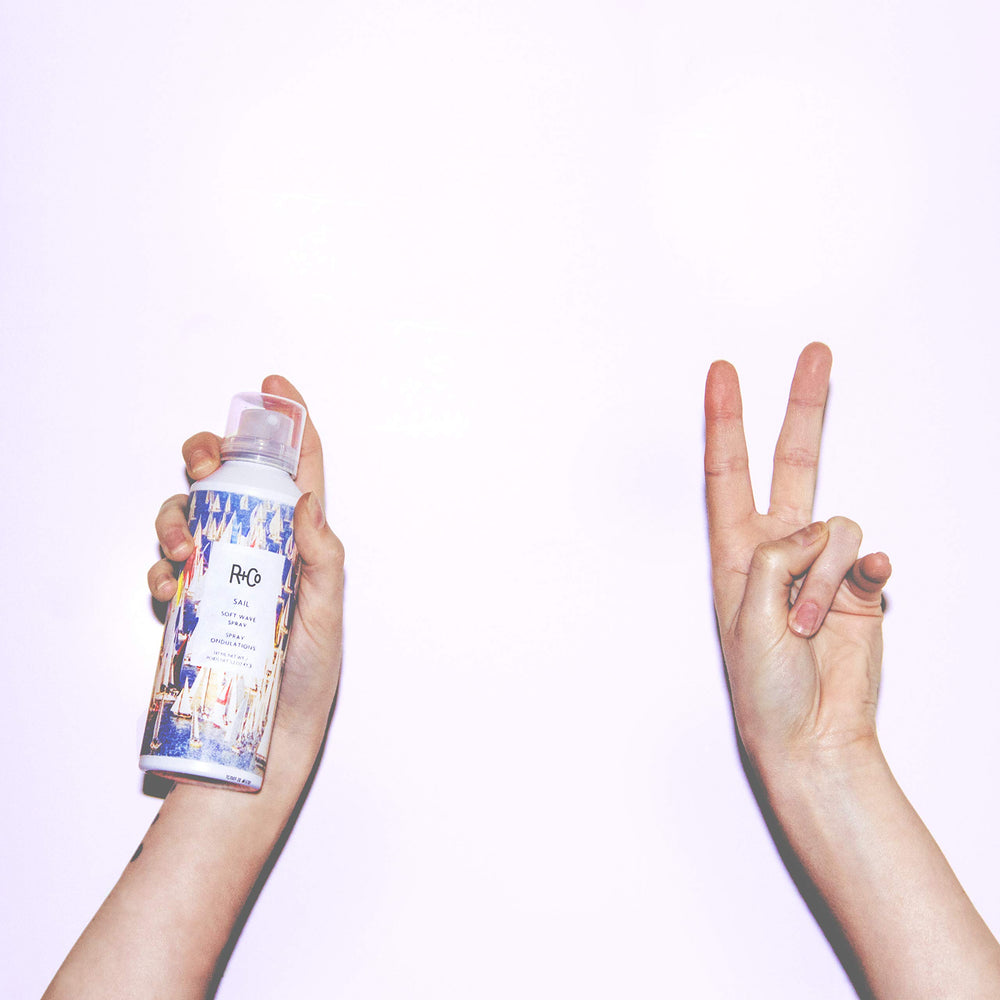 Application shot of R+Co Sail Soft Wave Spray distributing texture evenly through hair