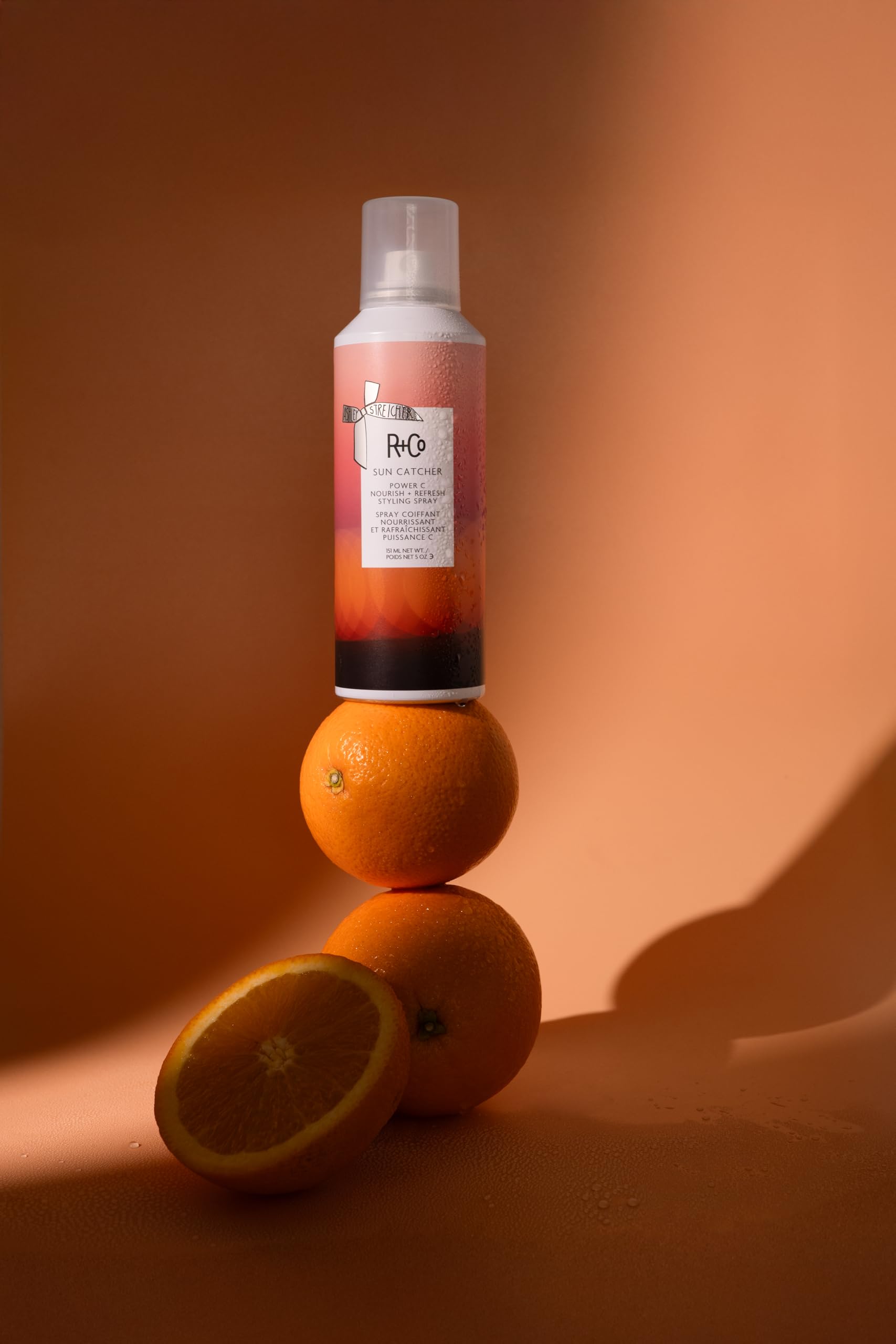 R+Co Sun Catcher leave-in mist applied to damp hair for hydration and heat protection